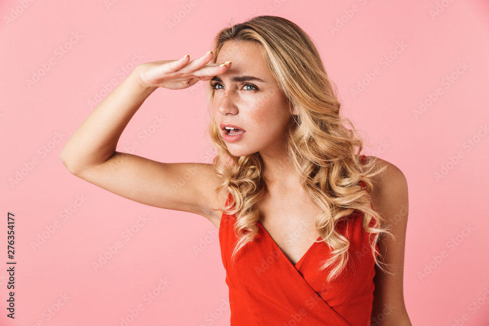 Sticker concentrated young blonde woman posing isolated over pink wall background looking aside.