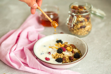 Granola with yogurt, honey and berries. Breakfast with berries and nuts. The correct breakfast. Delicious dish in the morning