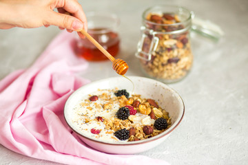 Granola with yogurt, honey and berries. Breakfast with berries and nuts. The correct breakfast. Delicious dish in the morning