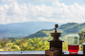 antique coffee grinder classic style on the shelf and mountain with cloud sky nature background