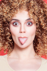 Fototapeta premium Beautiful young cheerful girl with shows tongue