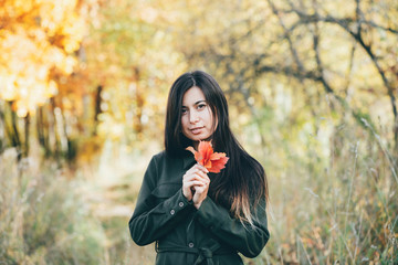 Female beauty portrait surrounded by vivid foliage. Dreamy beautiful girl with long natural black...