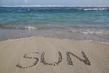 World sun written on the empty sandy beach