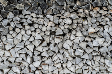 Background of splitted, dried and stacked firewood. Bunch of wood.