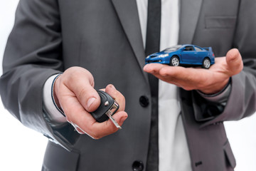 Man holding toy car and keys isolated on white