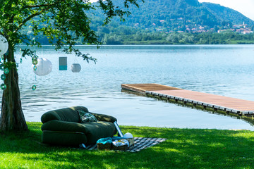 Sofa on the lake with wood pier and decorations