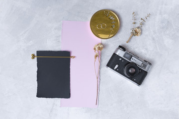 Set of blooms near papers, rings on round and retro camera