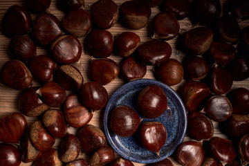 group of tasty chestnuts next to a bowl