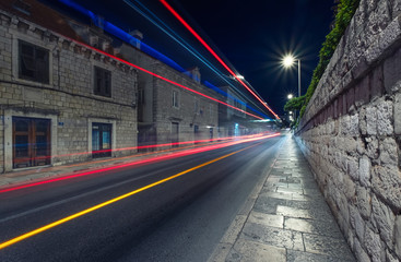 Night city and blured lights from cars. Traffic background in the town. Composition with transport traffic. Transportation - image