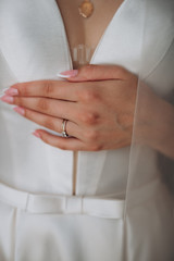 the bride holds the dress with her hand, a ring on her hand