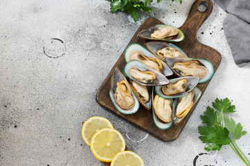 Kiwi mussels on a wooden Board on a gray background. Healthy diet