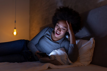 Woman lying in bed and having a video call