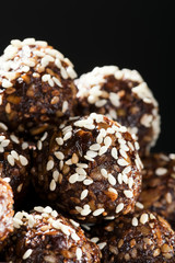 Raw homemade paleo energy balls with rolled oats, nuts, dates and sesame, horizontal, close up. Vegan sweet dessert