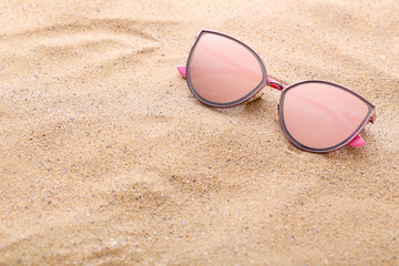 Modern sunglasses on the beach sand