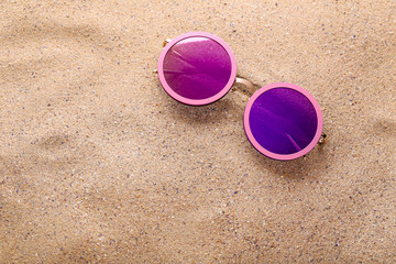 Fototapeta na wymiar Modern sunglasses on the beach sand