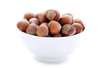 Hazelnuts in bowl isolated on white background