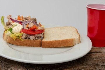 Sándwich de pollo con verduras y mayonesa.