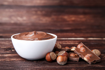 Melted chocolate with hazelnuts on brown wooden table