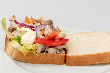 Sándwich de pollo con verduras y mayonesa.
