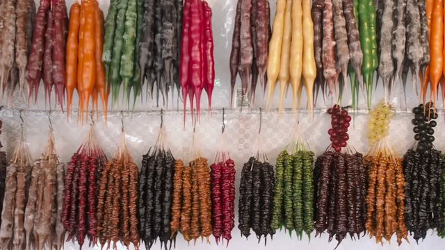 Panorama of sweet churchkhela at the farmer's market bazaar in Georgia . Colorful Churchkhela Hanging on the Market Showcase