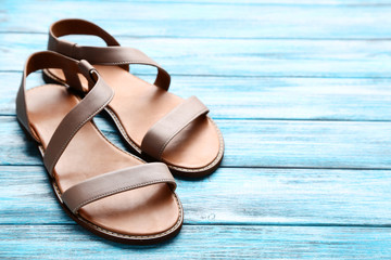 Female beige sandals on blue wooden table