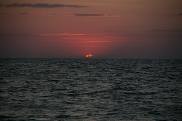 Fototapeta premium The setting sun going beyond the horizon of the Azov sea