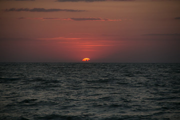 The setting sun going beyond the horizon of the Azov sea