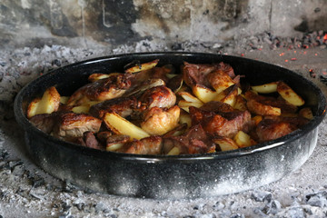 Dish with stew and potatoes cooked on the grill