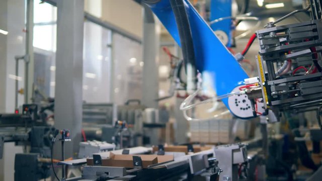 Factory device puts cardboard on a conveyor at a production center.