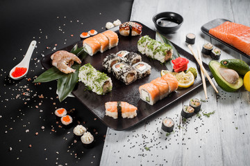 Sushi set with salmon, eel, tuna, avocado, cream cheese Philadelphia, caviar, chuka. Sushi menu. Japanese food on black and white background
