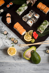 Sushi set with salmon, eel, tuna, avocado, cream cheese Philadelphia, caviar, chuka. Sushi menu. Japanese food on black and white background