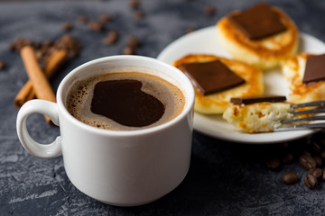 A Cup of fragrant espresso coffee and cheesecakes with chocolate and cinnamon