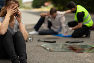 Female driver guilty of car accident sitting on the road