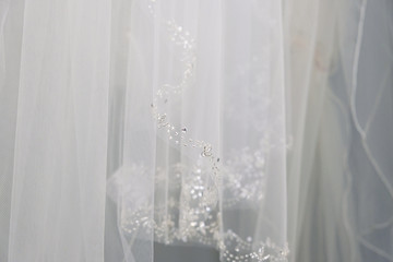 Bride dress close up shows white lace with beading detail for wedding.