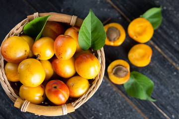 Naklejka na ściany i meble Ripe red apricots in a wooden basket
