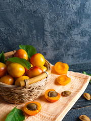 Ripe red apricots in a wooden basket