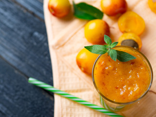 Delicious apricot smoothie in a glass with a straw
