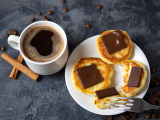 A Cup of fragrant espresso coffee and cheesecakes with chocolate and cinnamon