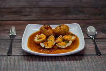 Egg with Tamarind Sauce (Kai Look Keuy or Son-in-Law Eggs) on a wooden background