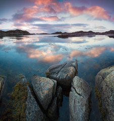 Long exposure shot. Reflection in the sea with stone beach on the sunset Sea waves lash line impact rock on the beach