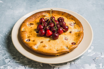 Traditional homemade cheesecake with cherries on the wooden table. Selective focus. Shallow depth of field.