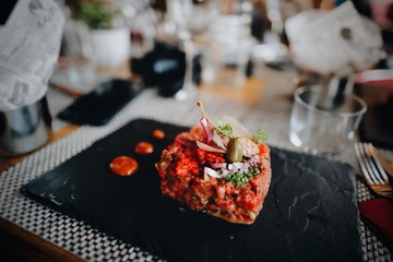 Steak tartare served on stone plate.