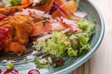 Meat in batter with vegetables on a plate