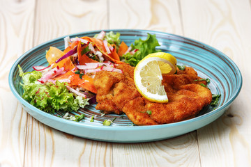 Meat in batter with vegetables on a plate