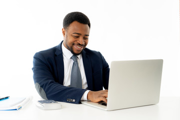 Attractive happy handsome african american businessman working on laptop computer on desk at office