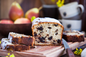 Delicious homemade chocolate and pears loaf cake on rustic wooden background