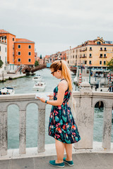 Fototapeta na wymiar Young woman holding a map in Venice. Italy
