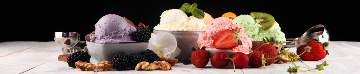 ice cream scoops of different colors and flavours with berries, nuts and fruits decoration on white background