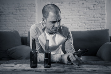 People, depression men and alcohol addiction concept. depressed man drinking alcohol at home alone