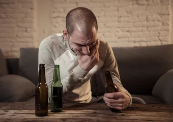 Tuinposter People, depression men and alcohol addiction concept. depressed man drinking alcohol at home alone © SB Arts Media